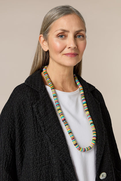 An ethically sourced woman wearing an adjustable waxed cord Long Coco Disc Necklace.