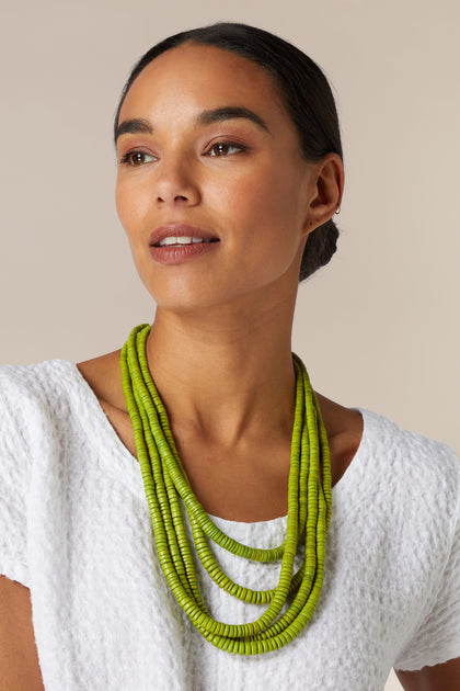 A woman wearing a Coconut Shell Disc Necklace.