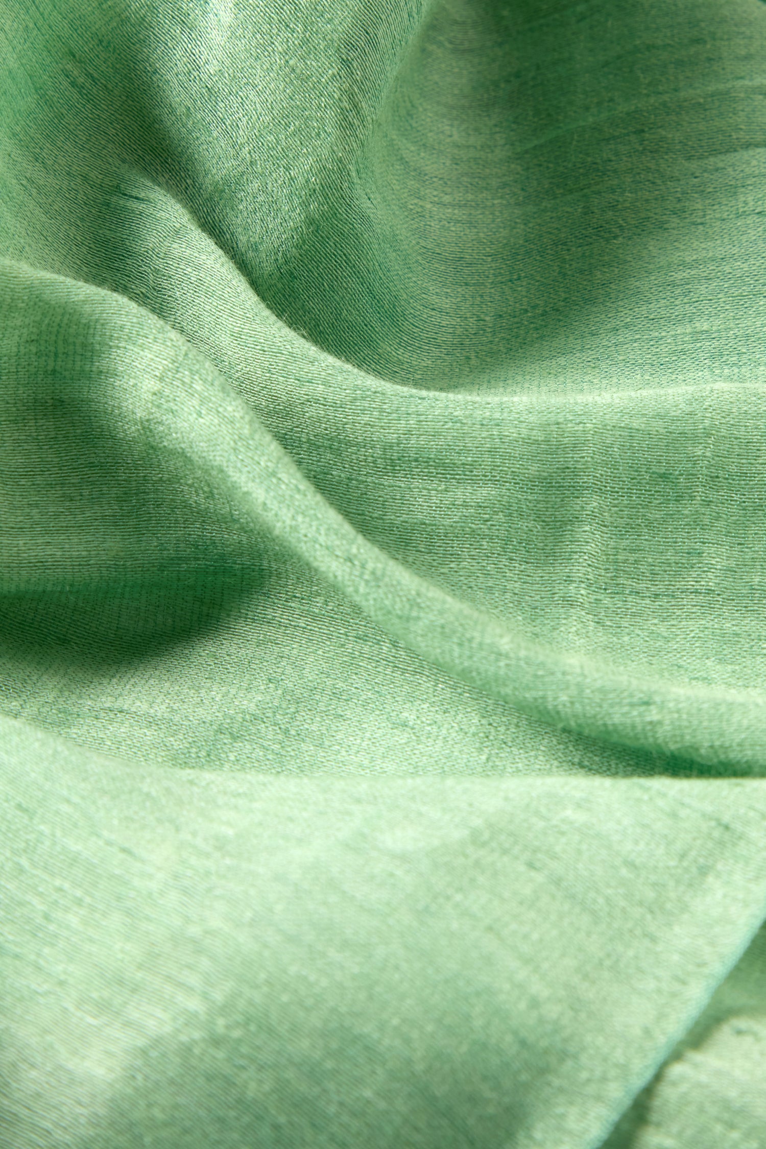 Close-up of an Olive Soft Linen Fringe Scarf, featuring a light green linen-silk blend with a smooth texture and visible folds—ideal for a lightweight accessory.
