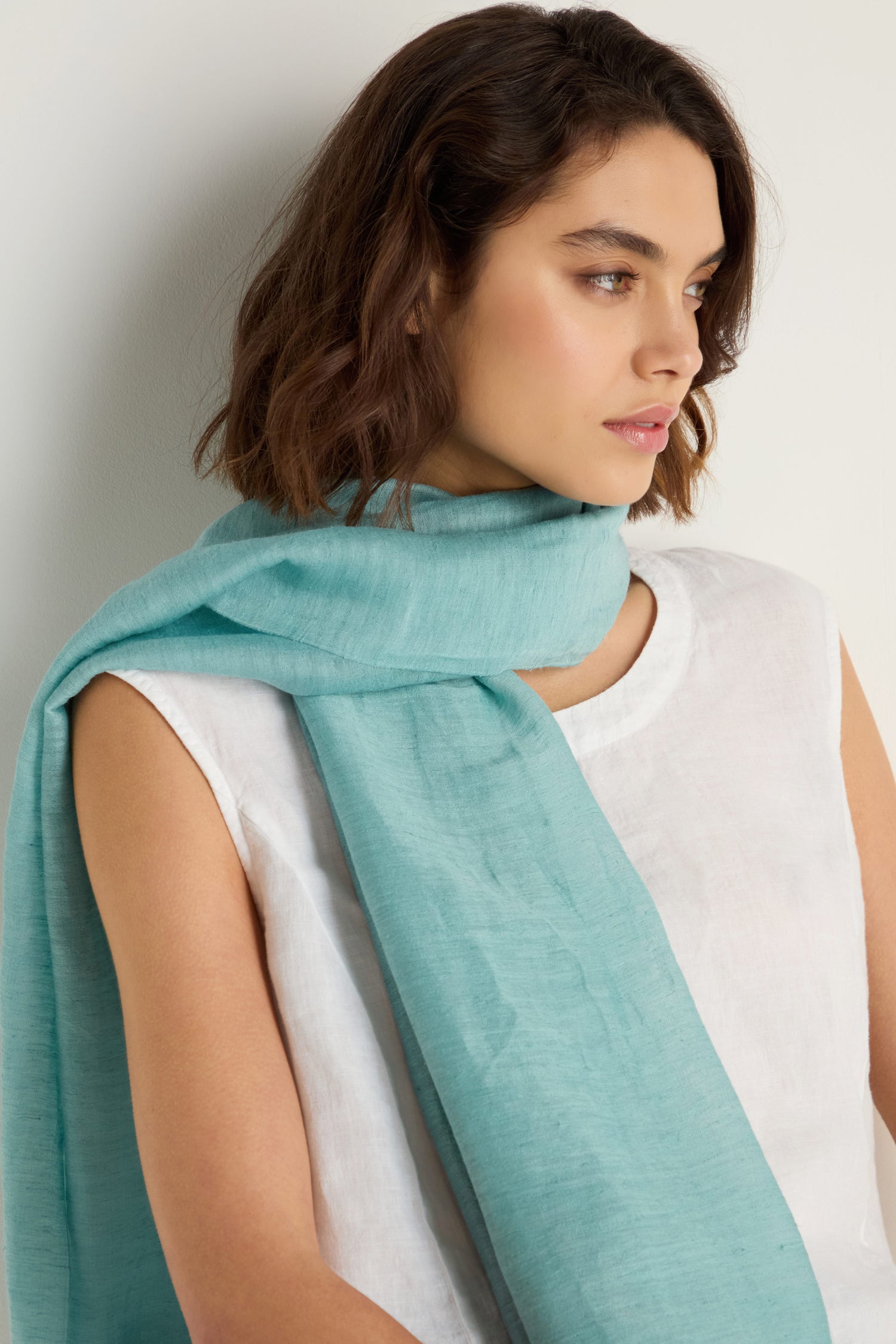 A woman wearing a Soft Linen Fringe Scarf as a lightweight layering accessory.