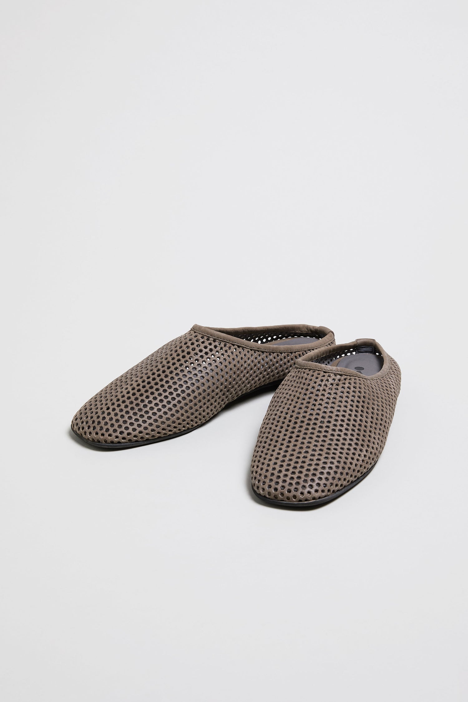 Mesh Leather Slip on Shoes: A handmade pair of brown perforated leather slip-ons with a mesh-like texture, crafted in Europe and displayed on a plain white background.