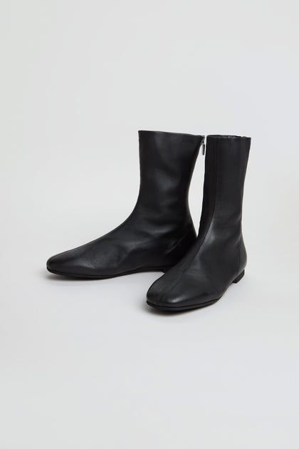 A pair of Slim Napa Leather Stretch Boots in black, featuring a mid-calf slim design with side zippers, displayed on a plain white background.