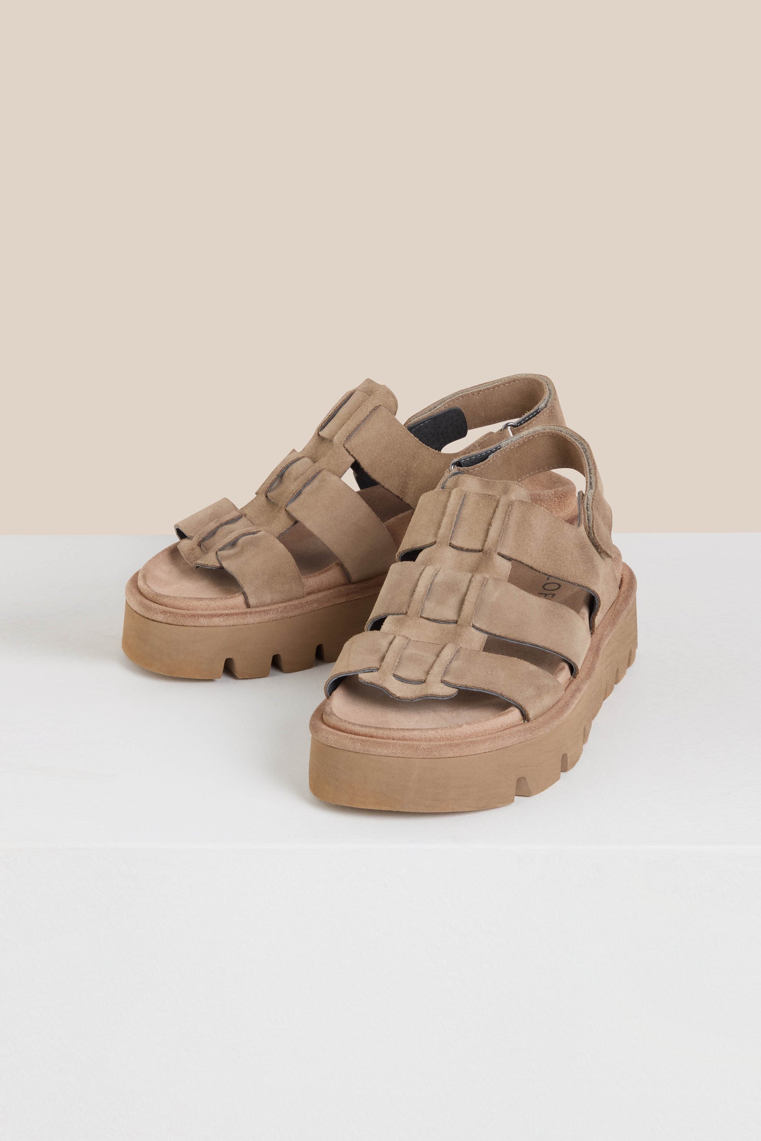 Brown Italian-crafted Suede Platform Velcro Sandals with multiple straps gracefully rest on a white surface against a beige background, presented in a Sahara colourway for style and comfort.