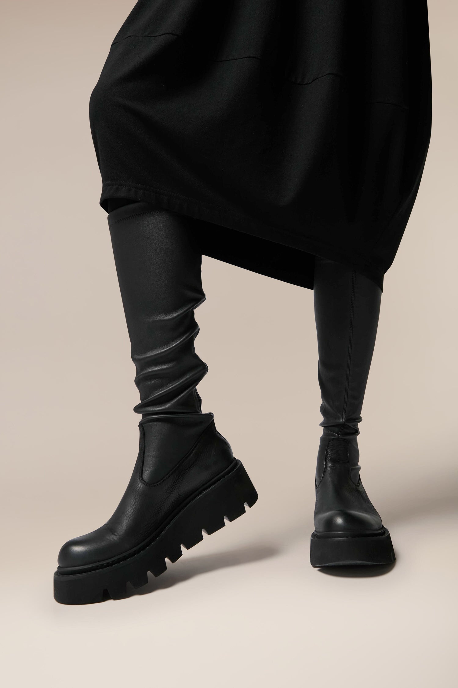 A woman showcasing Danish design and Italian craftsmanship while donning Long Stretch Leather Boots and a black skirt.