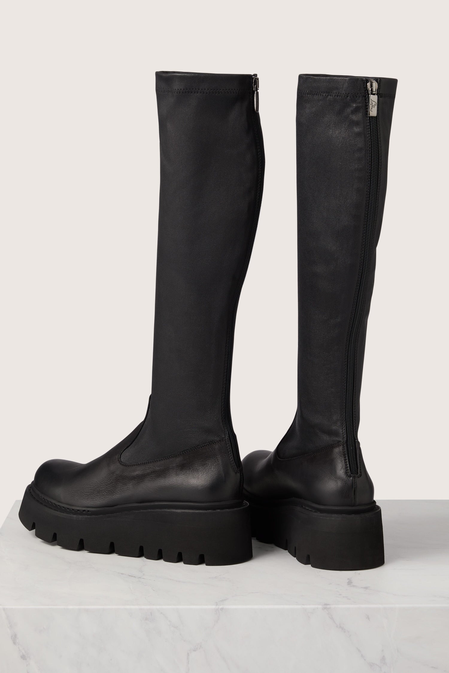 A pair of Long Stretch Leather Boots with Italian craftsmanship and a side zipper.