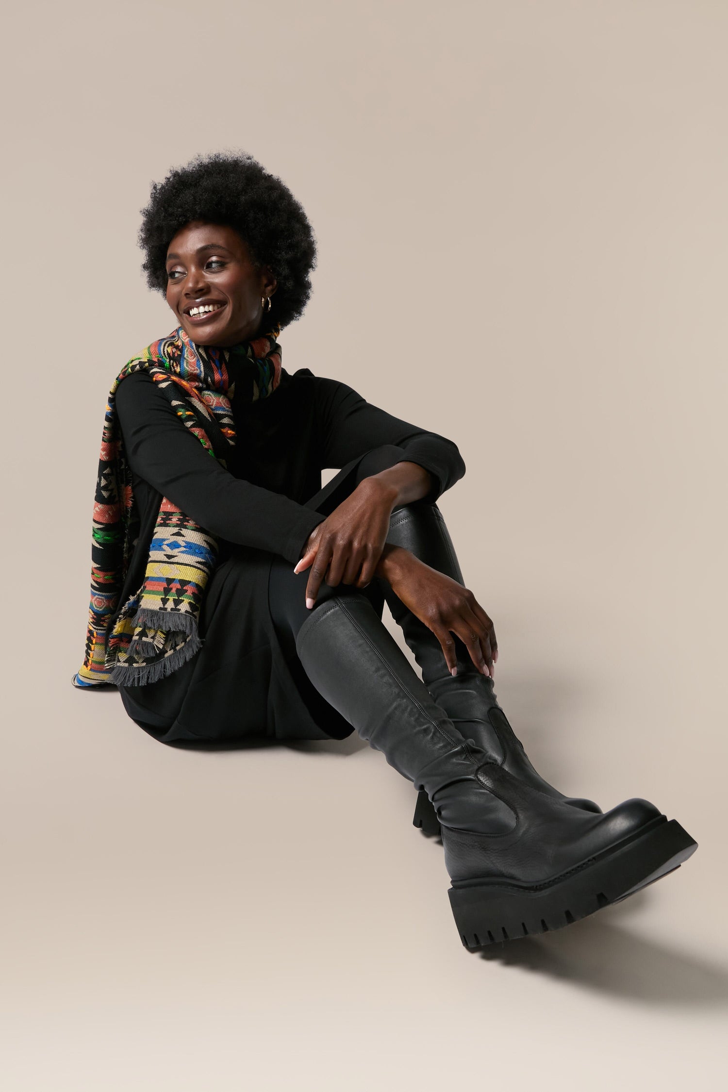 A black woman wearing Long Stretch Leather Boots.