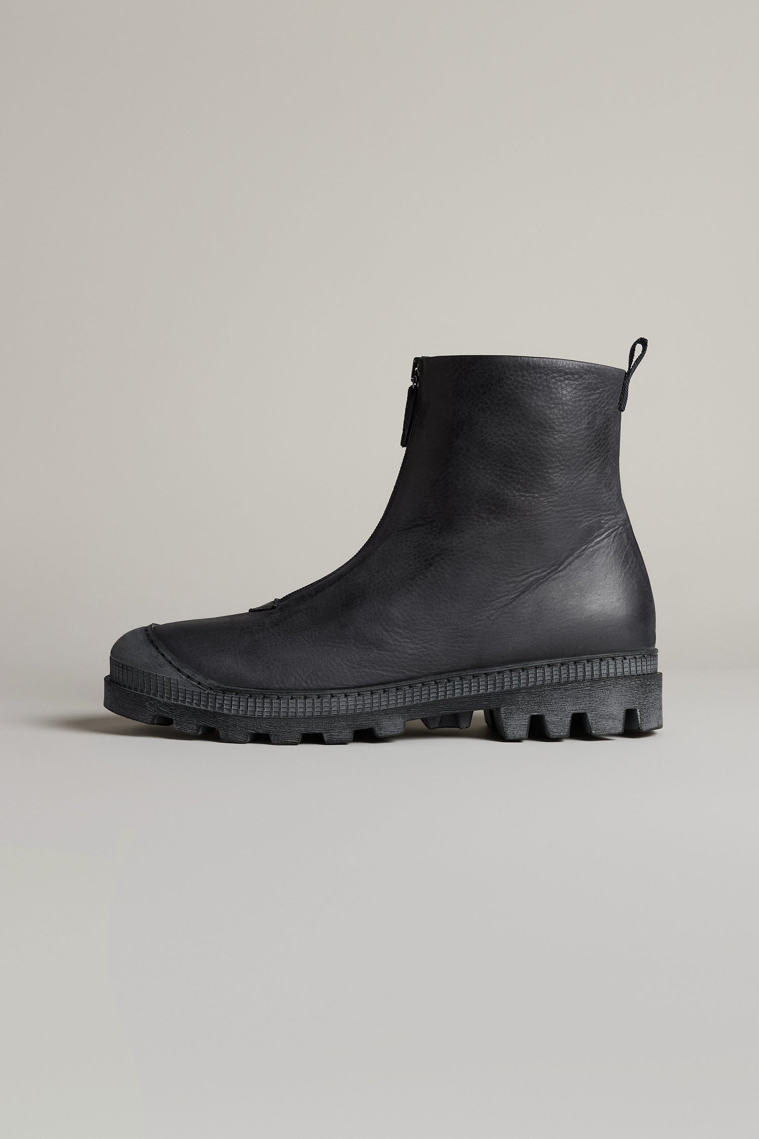 The Black Zip Front Leather Boots are premium ankle boots handcrafted in Italy, featuring black leather, a textured sole, and a front zipper. Shown in profile against a plain background.