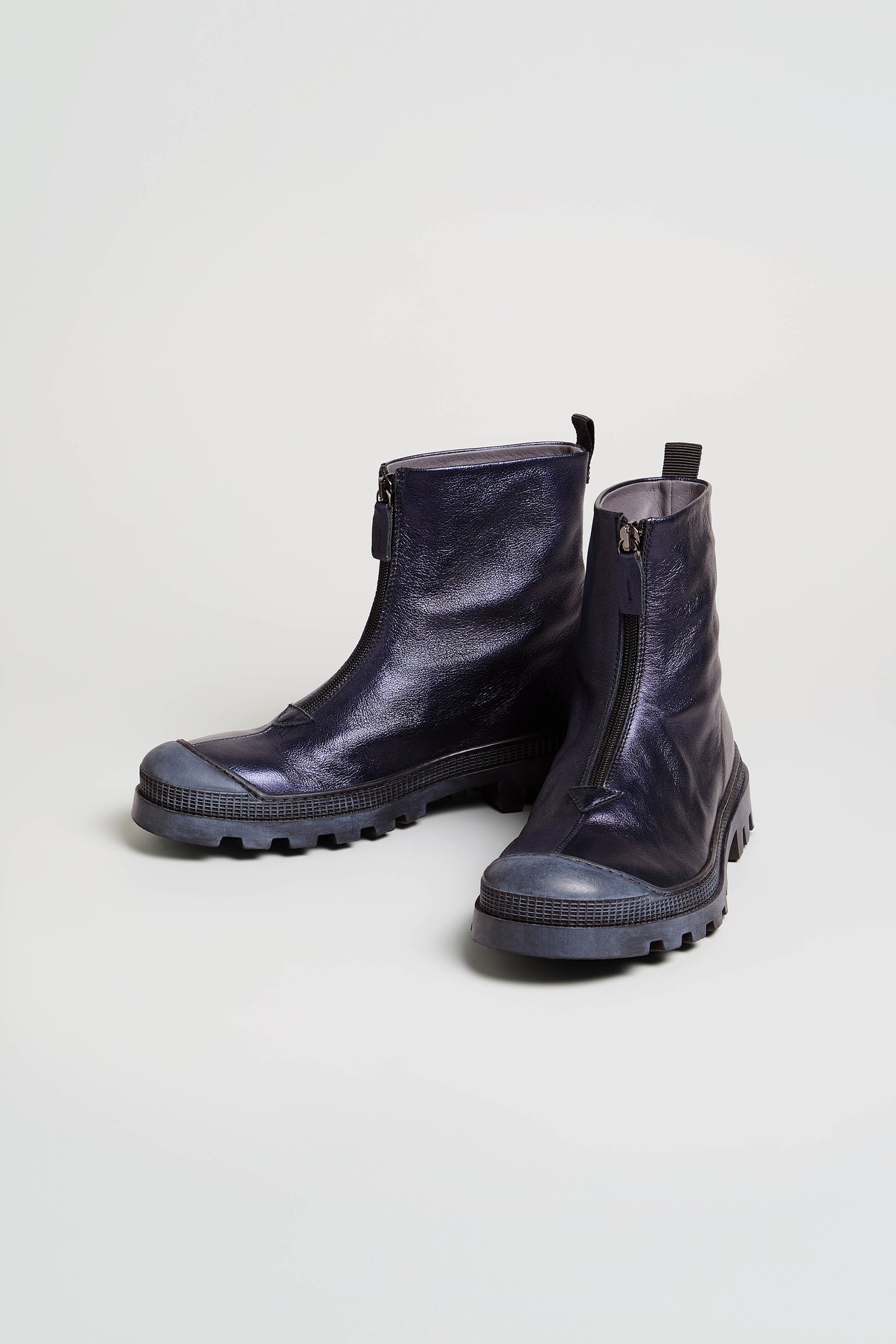 A pair of Metallic Blue Violet Zip Front Leather Boots with chunky tread soles is displayed on a plain light background.
