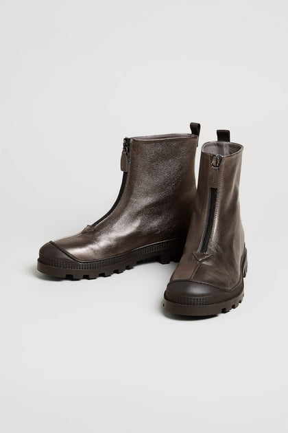 A pair of Metallic Hematite Zip Front Leather Boots, crafted from metallic gray leather with black chunky tread soles and front zippers, displayed on a plain white background.