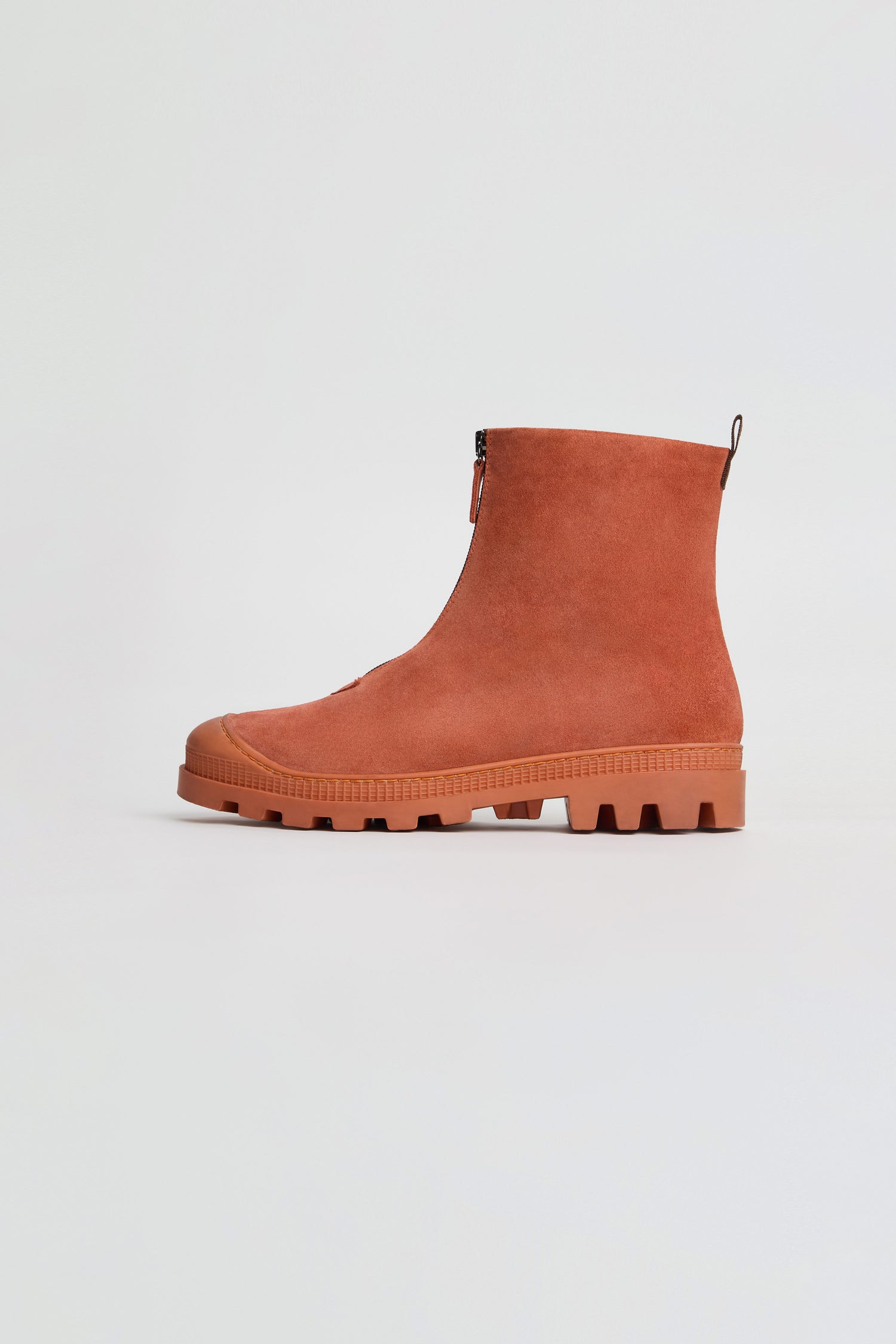 A single Zip Front Suede Boot in rust-colored suede, inspired by the classic handmade Italian Lofina style, features a side zipper and a thick treaded sole, displayed against a plain white background.