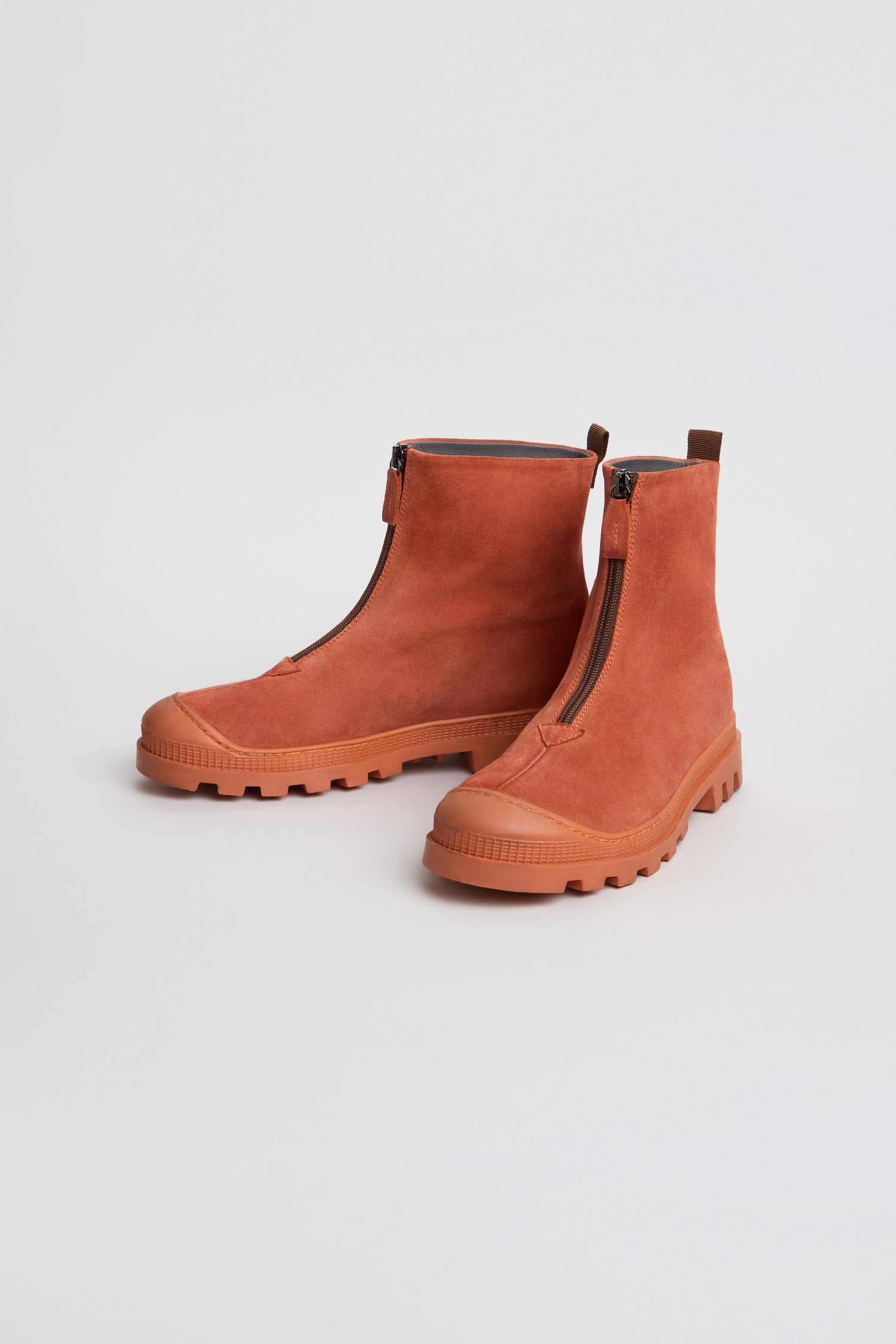 A pair of Zip Front Suede Boots in rust, handmade in Italy with front zippers and chunky rubber soles, displayed on a plain white background.