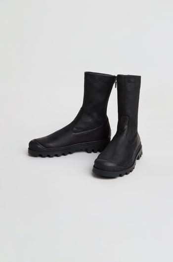 A pair of Stitch Detail Napa Leather Stretch Boots in black, featuring rugged rubber soles and a mid-calf silhouette, are positioned on a plain white background.
