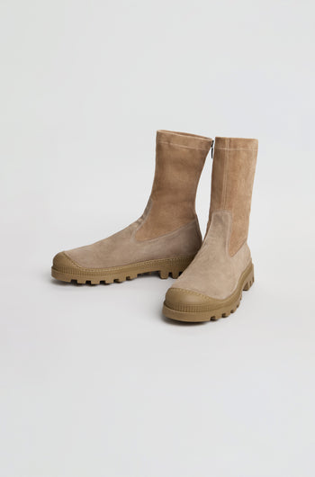 A pair of Stitch Detail Suede Stretch Boots in taupe suede, handmade in Italy with textured rubber soles and a stylish mid-calf silhouette, displayed on a plain white background.