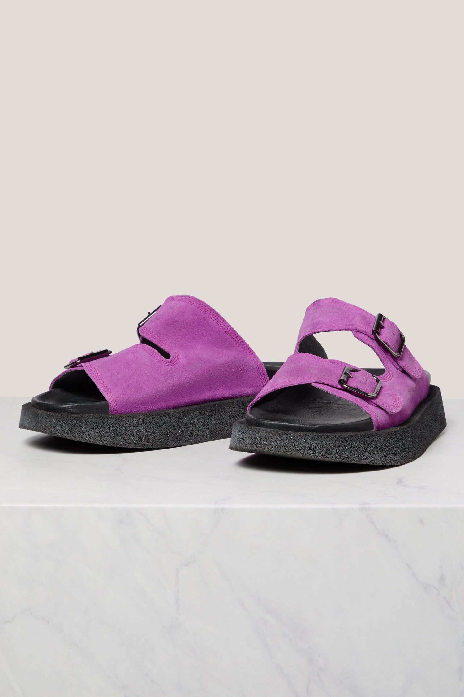 A pair of purple Suede Double Buckle Slider sandals with Italian construction on a white surface.