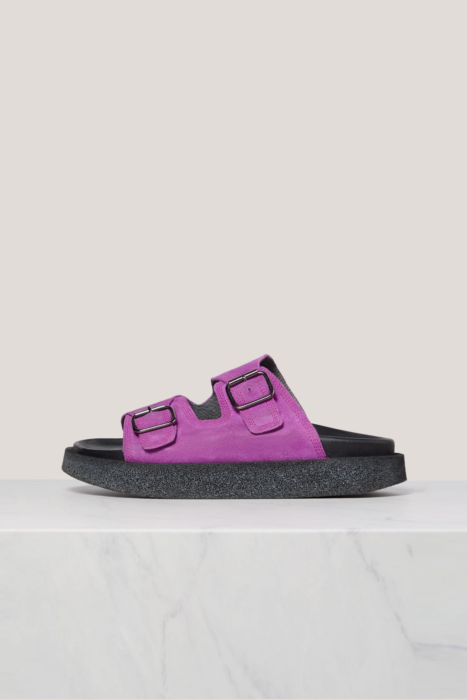 Purple Italian Suede Double Buckle Slider sandal on a white surface against a gray background.