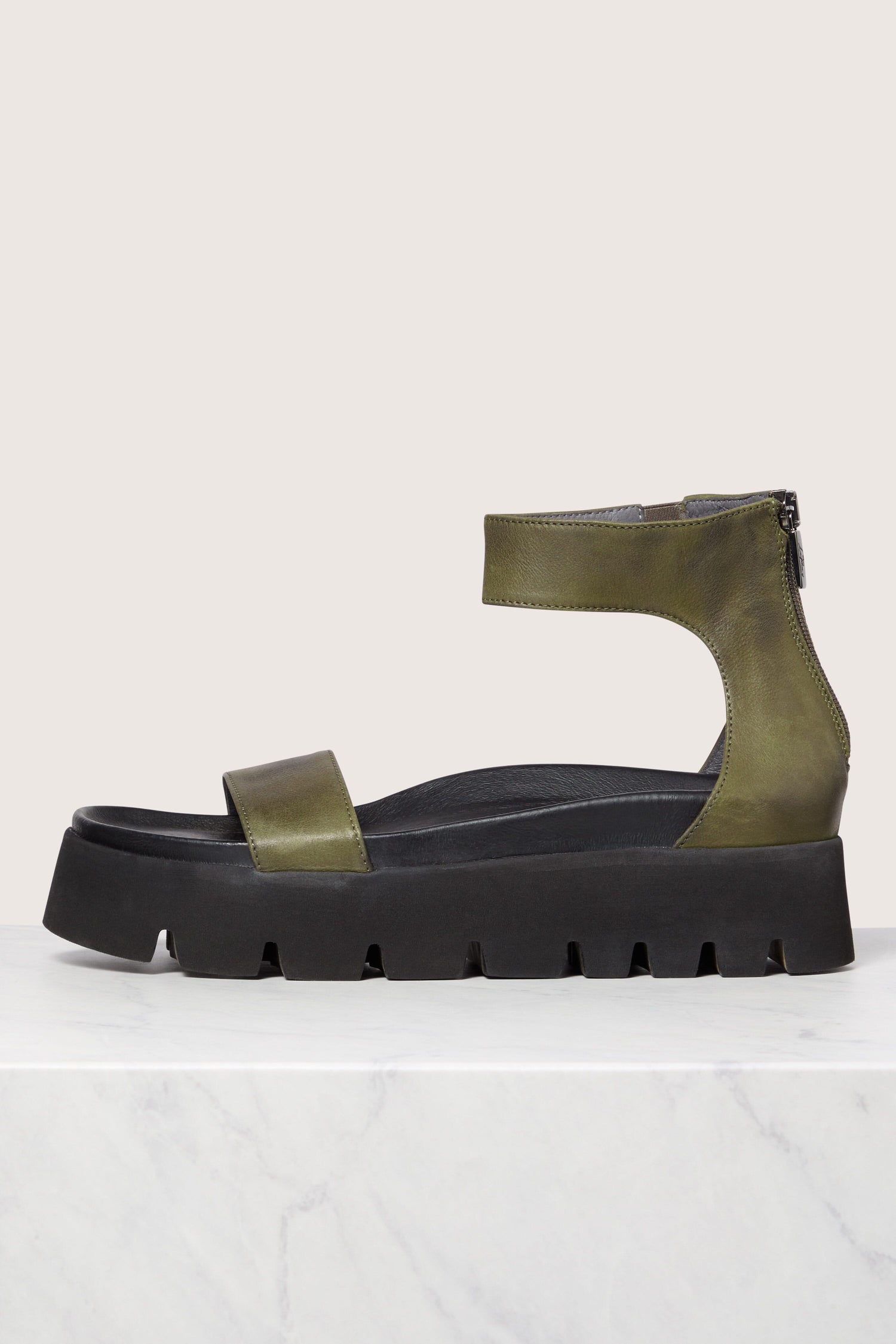 A single Leather Platform Zip Sandal with a chunky black sole against a marble background.