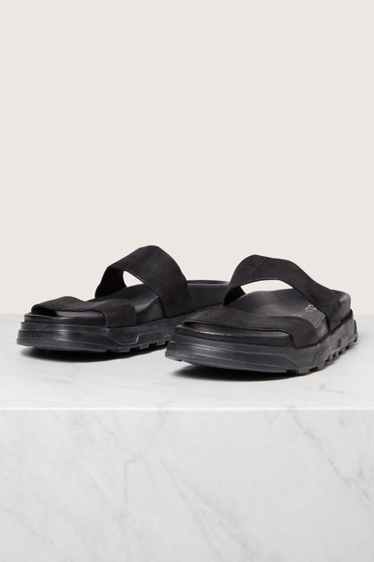 A pair of black stretch leather slider sandals displayed on a white surface, showcasing Italian construction.