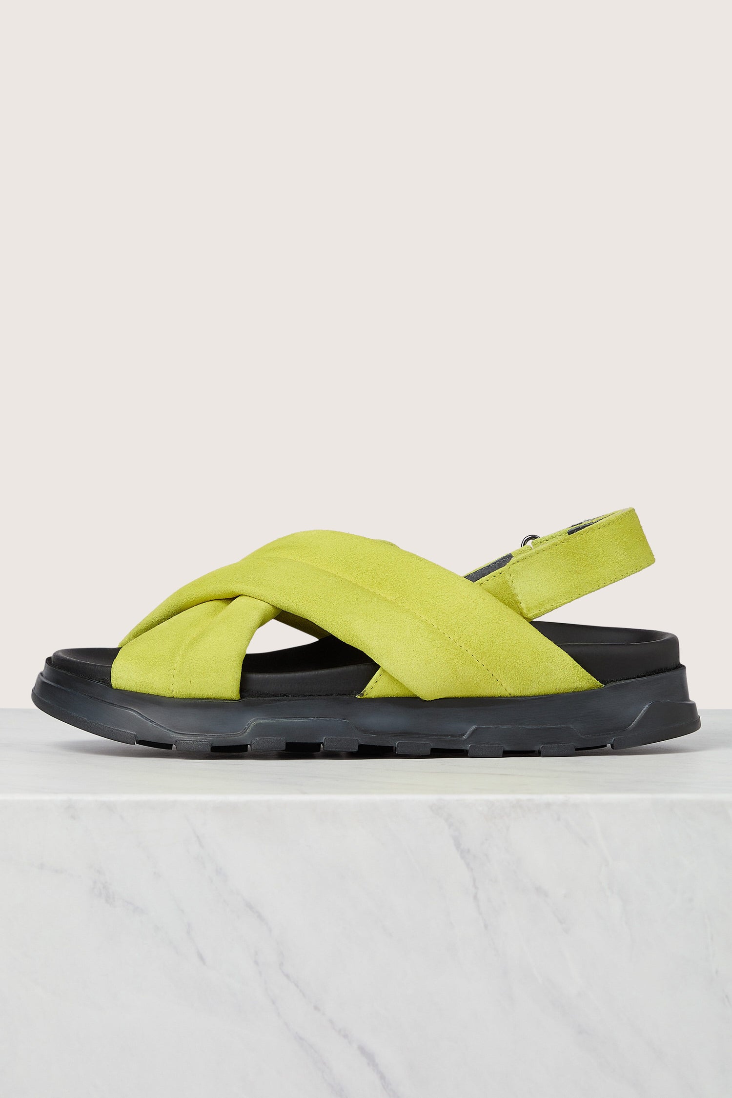 Neon green suede crossover sandal on a white surface.