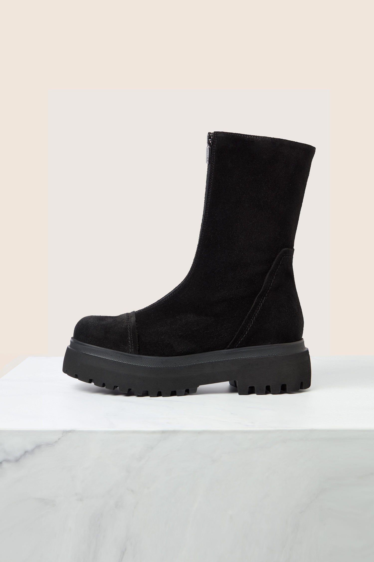 A pair of Zip Front Suede Platform Boots in black suede, boasting a mid-calf height and thick rubber sole, is elegantly displayed on a marble surface against a neutral background.