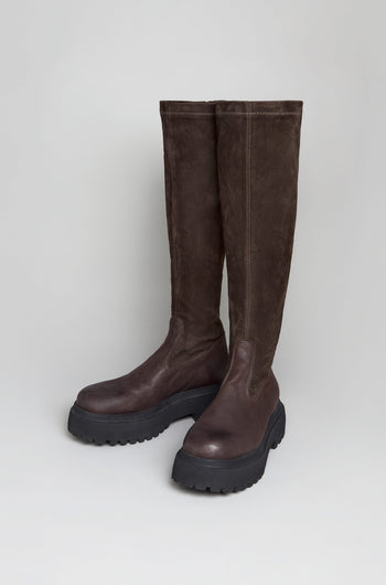 The Chocolate Long Stretch High Knee Suede Boots, featuring chunky black platform soles and crafted from suede and leather, stand upright against a plain light background.
