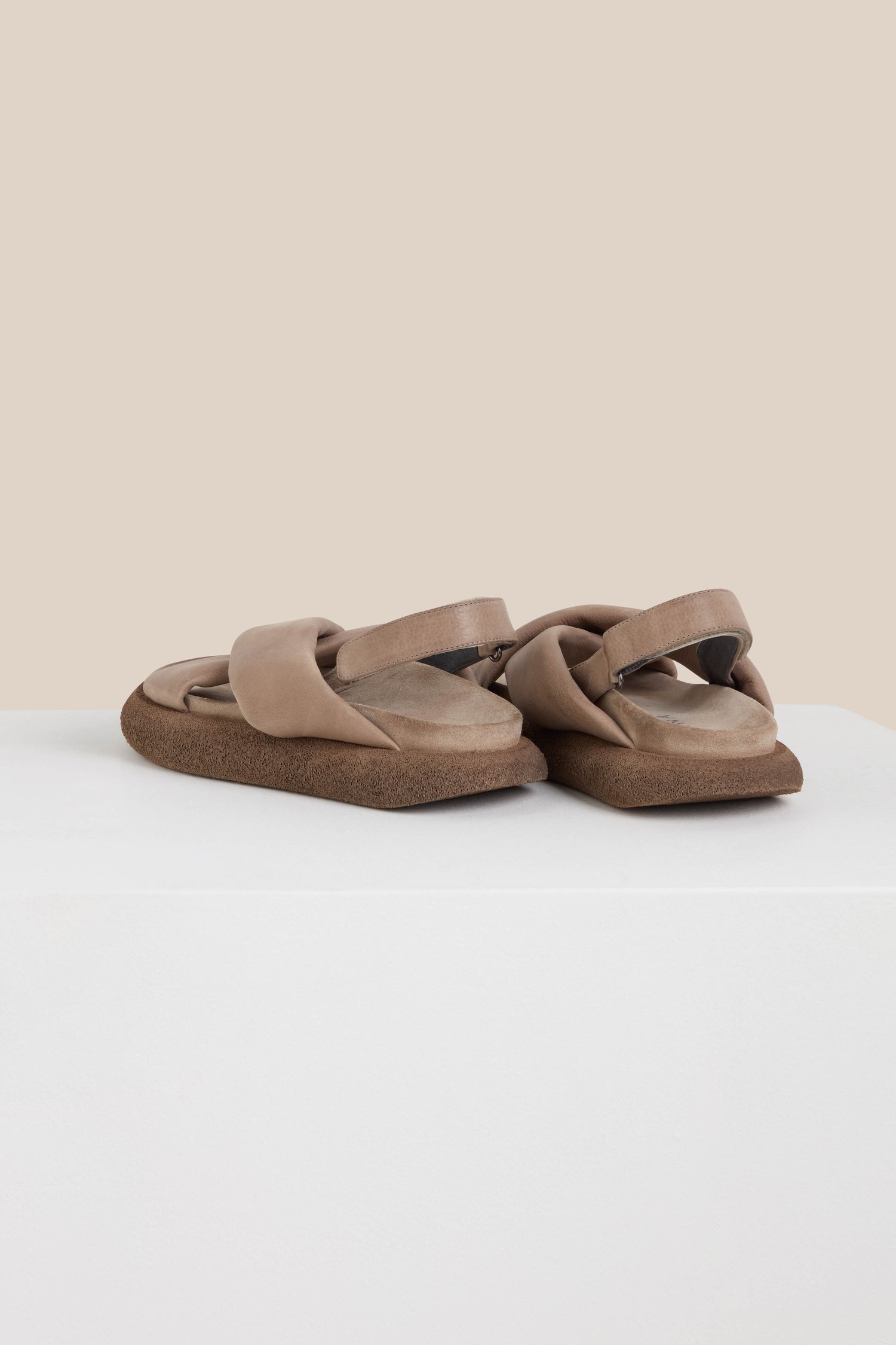 A pair of Crossover Leather Sandals in brown, featuring thick straps and a cushioned footbed with impeccable Scandinavian craftsmanship, displayed on a white surface.