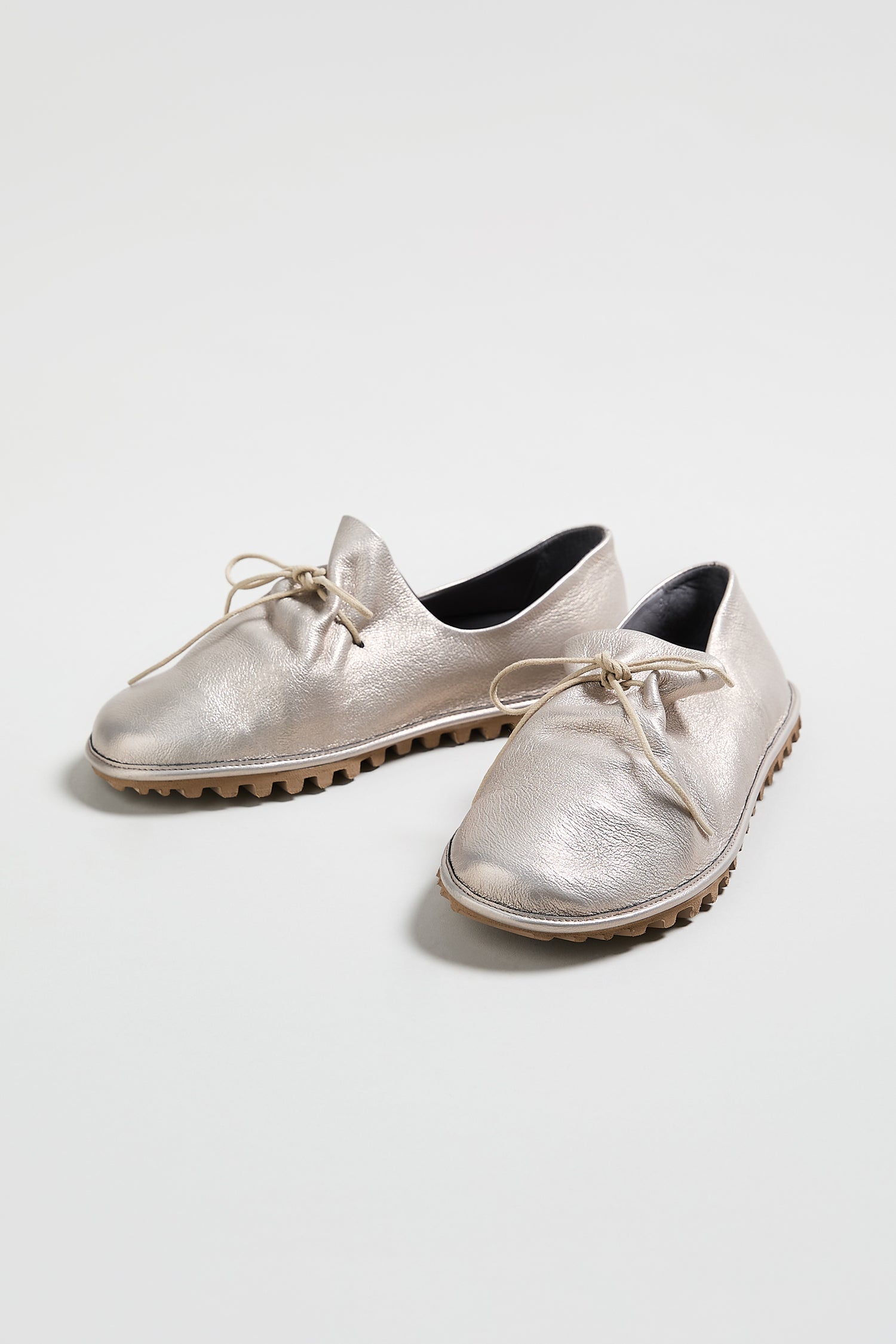 A pair of Crushed Leather Lace Up Shoes in metallic silver, style LOFI9944-SS26, with textured soles are displayed on a white surface.