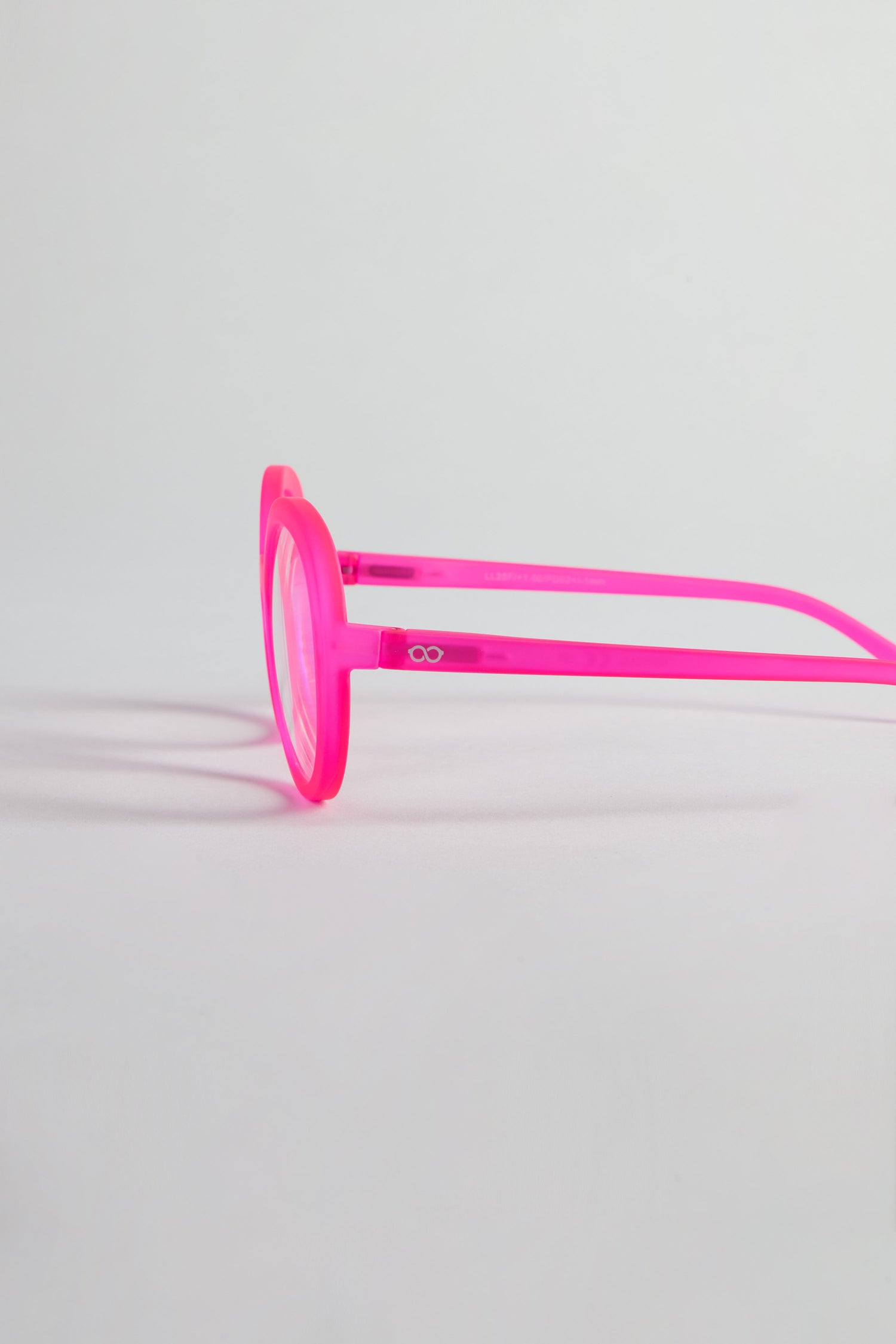 Neon Pink Round Reading Glasses with optician-quality lenses, shown in profile against a light gray background.