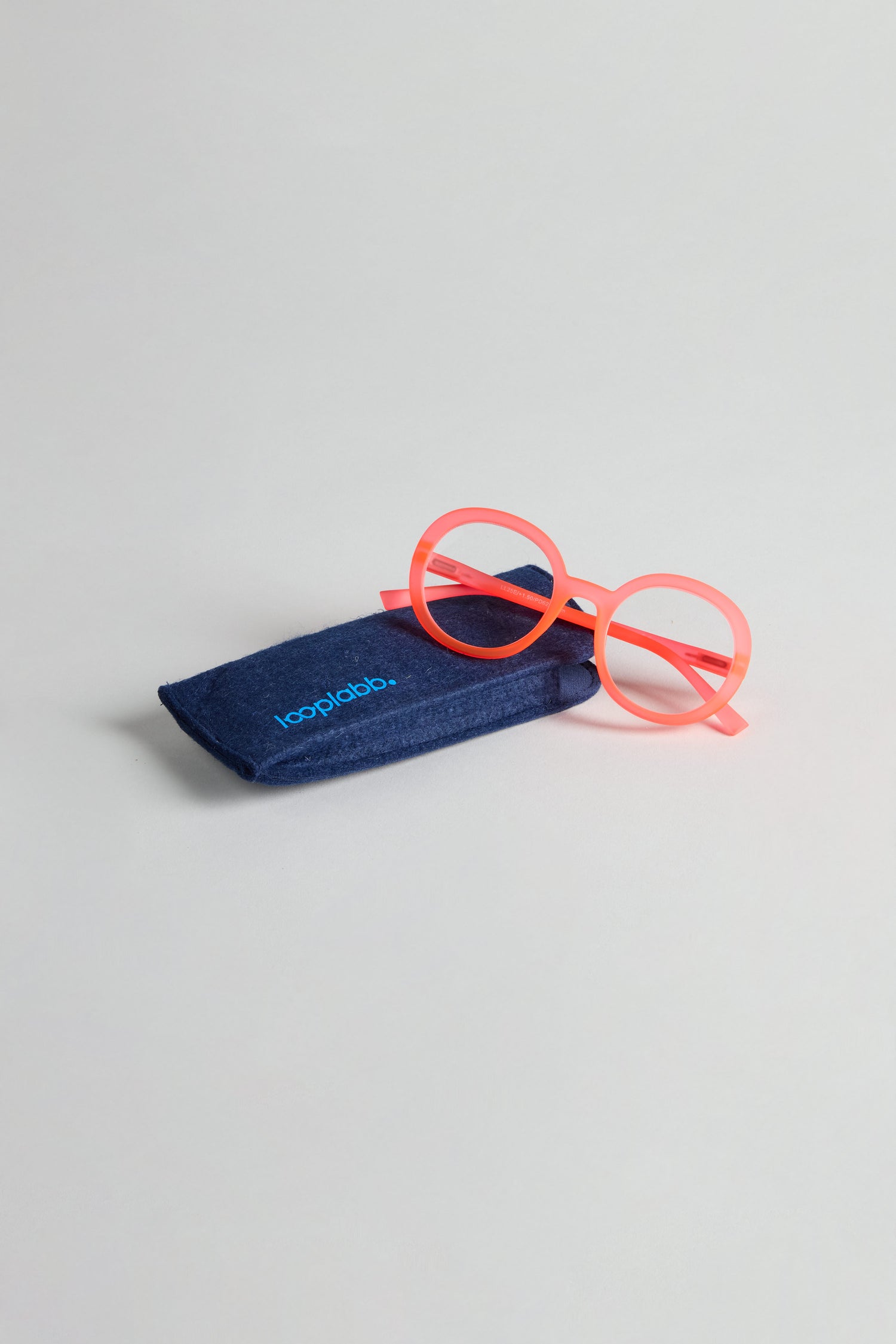 Neon Peach Round Reading Glasses sit beside a dark blue case labeled “looplabb,” featuring optician-quality lenses.