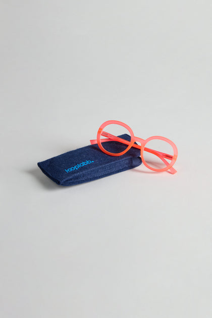 Neon Peach Round Reading Glasses sit beside a dark blue case labeled “looplabb,” featuring optician-quality lenses.