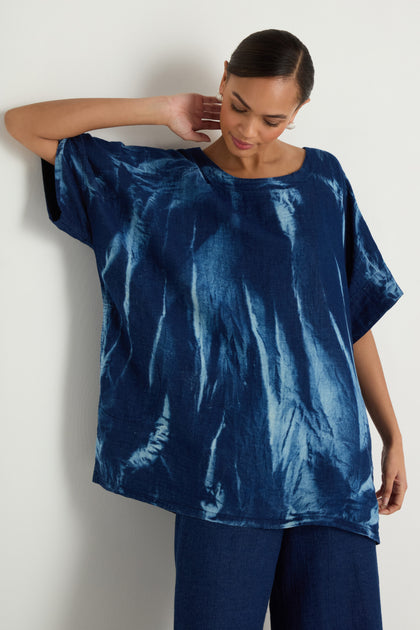 A woman models the Soft Denim Button-Back Tunic with matching blue pants, featuring a longline silhouette, against a plain light backdrop.