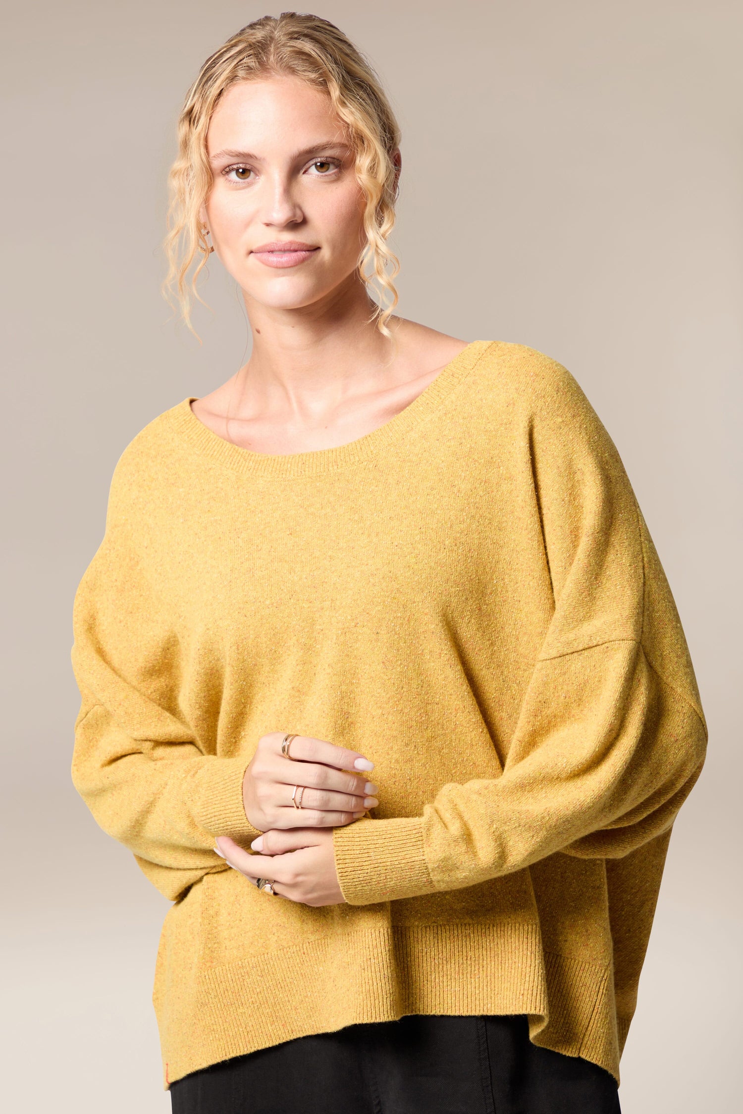 A woman wearing a Granit Scoop Knit sweater.