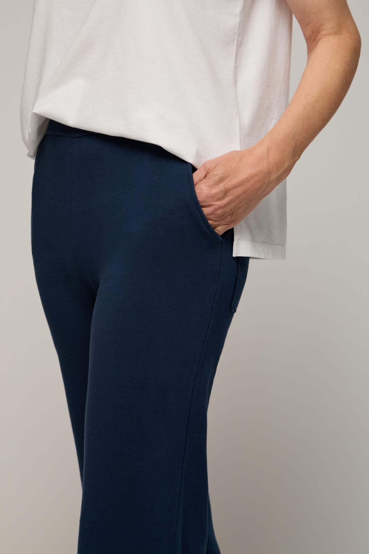 Person wearing a white top and navy Lana Pant, featuring an elasticated waist and pocket detail, shown from shoulder to mid-thigh against a plain background—a chic, relaxed look.