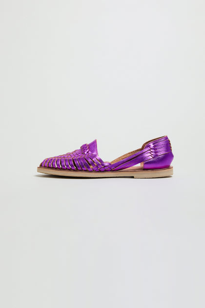 The Metallic Purple Alegre Leather Huarache Sandal features a closed toe and flat sole, crafted from woven leather and handmade in Mexico. Shown as a single sandal against a plain white background.