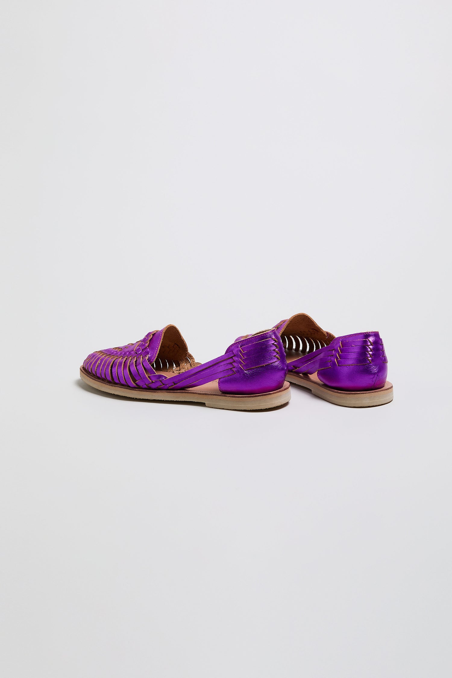 The Metallic Purple Alegre Leather Huarache Sandals, handcrafted in Mexico with tan soles, are displayed on a plain white background.