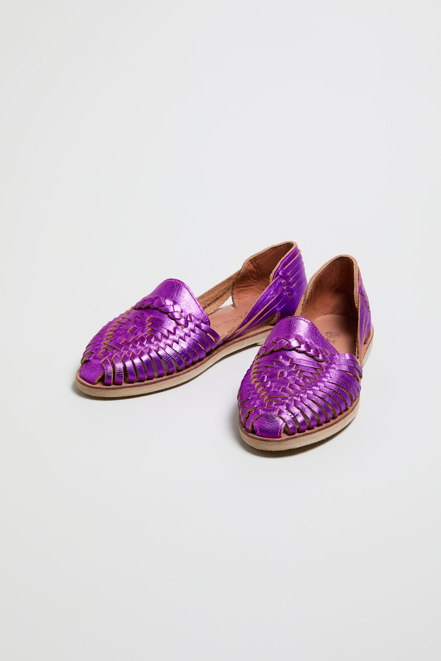 The Metallic Purple Alegre Leather Huarache Sandals, handcrafted in Mexico with woven leather uppers and flat soles, are shown against a plain white background.