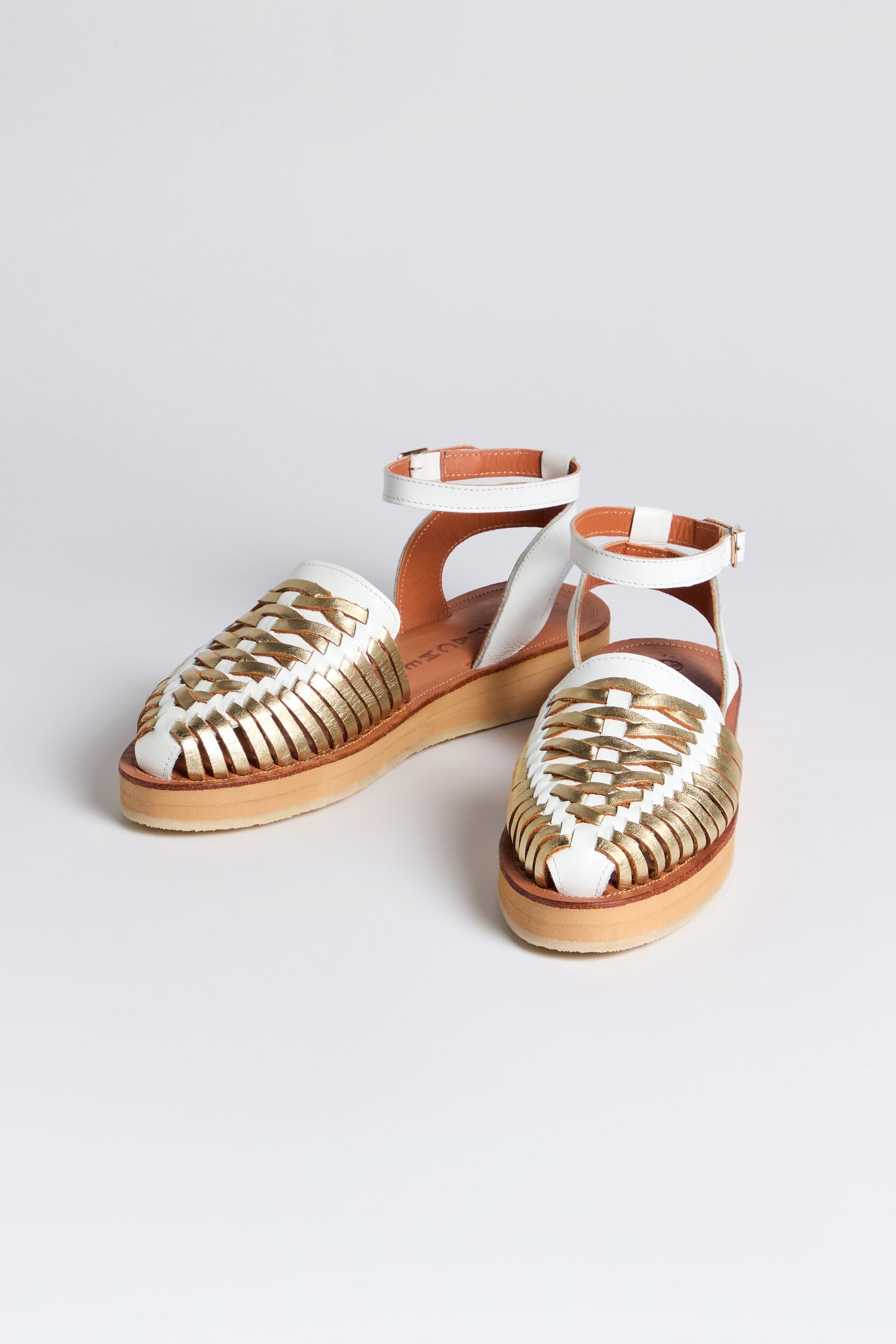 The Loma Platform Braided Leather Sandals feature handcrafted braided leather and ankle straps, beautifully displayed on a neutral background.