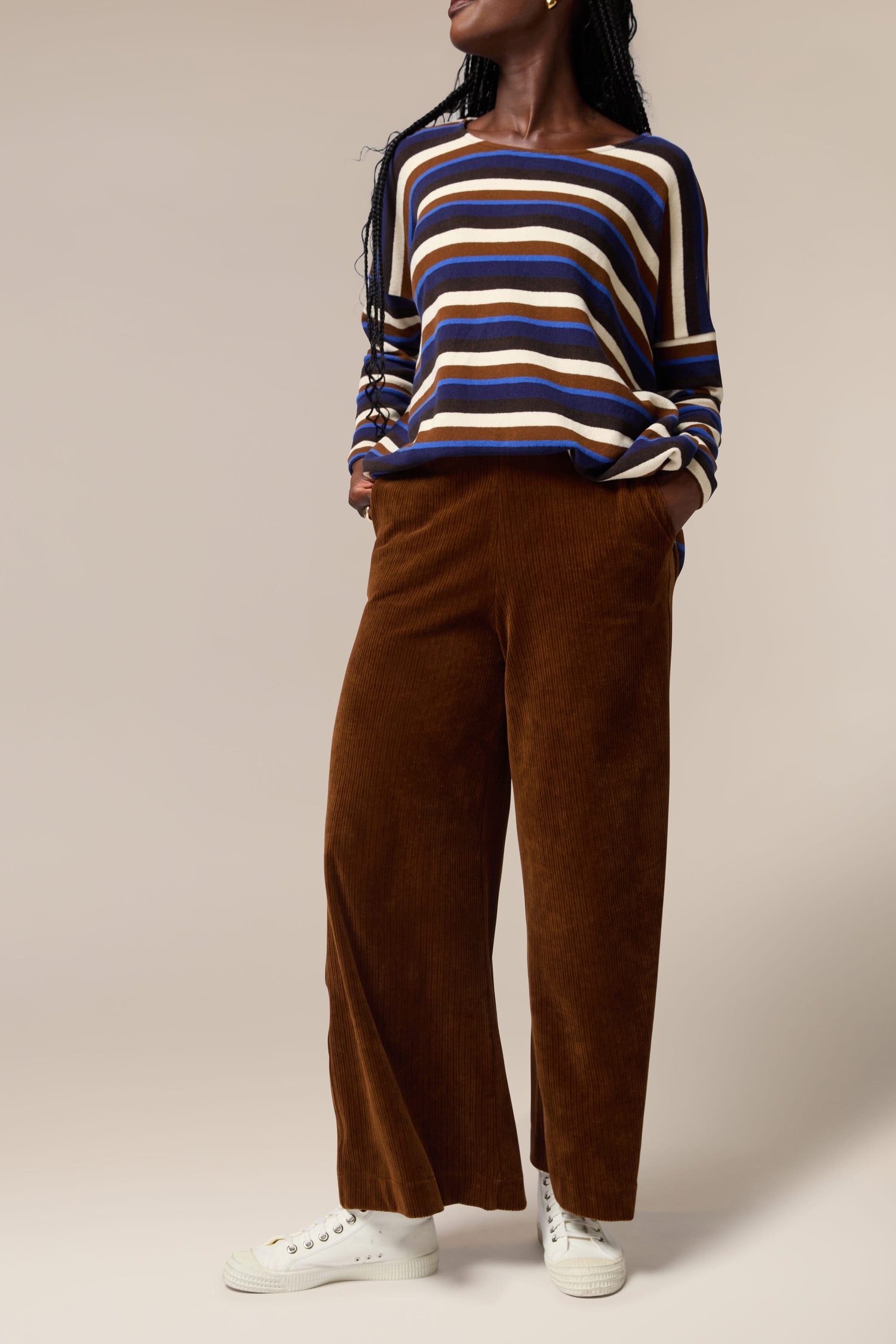 A Mama B wearing a striped sweater and Bulbo Velvet Wide Leg Trouser pants made of cord fabric.