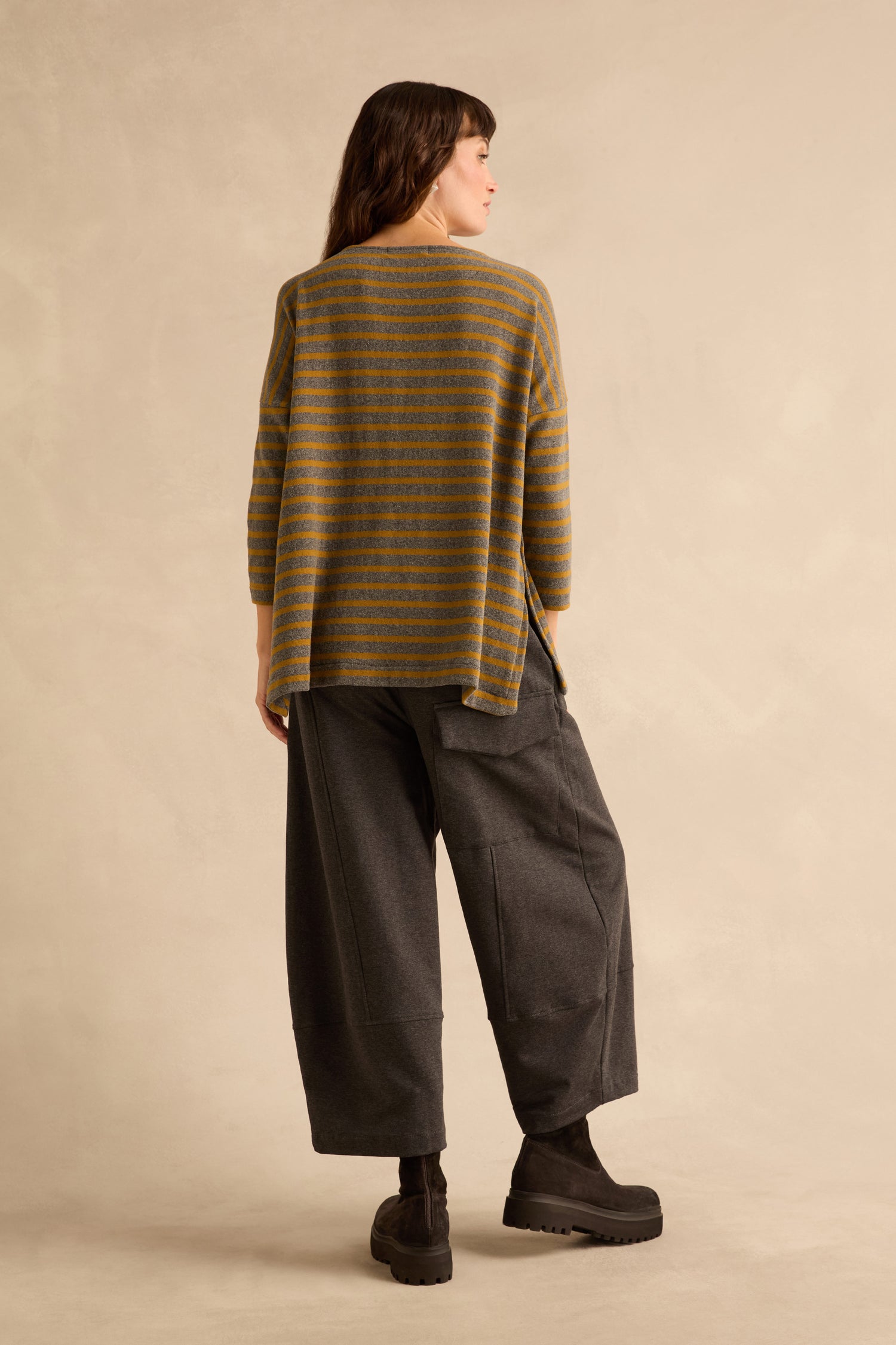 A person viewed from behind, wearing a Scoop Neck Wide Stripe Jersey Top, dark wide-leg trousers, and black lug-sole boots.