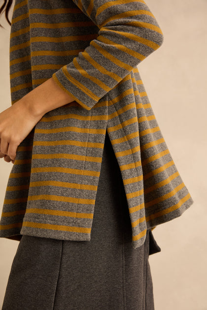 A person wearing a relaxed-shape Scoop Neck Wide Stripe Jersey Top in grey and mustard yellow with a side vent.