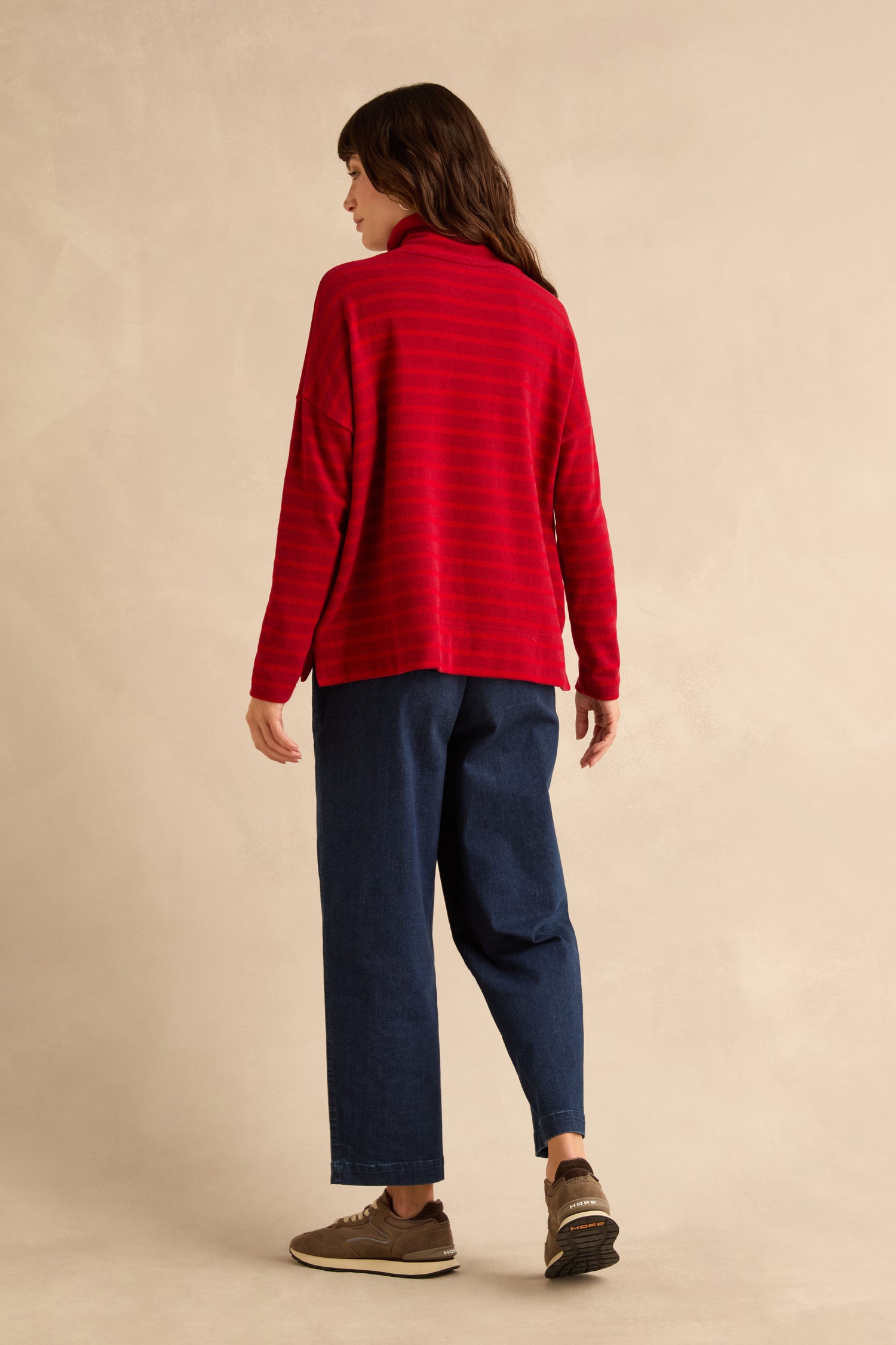 A person seen from the back wearing a Roll Neck Ruby Wide Stripe Jersey Top and dark blue trousers.