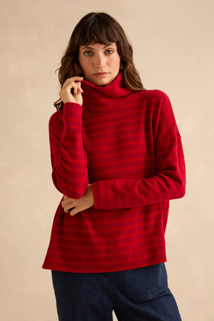 A person wears a Roll Neck Ruby Wide Stripe Jersey Top paired with dark blue jeans.