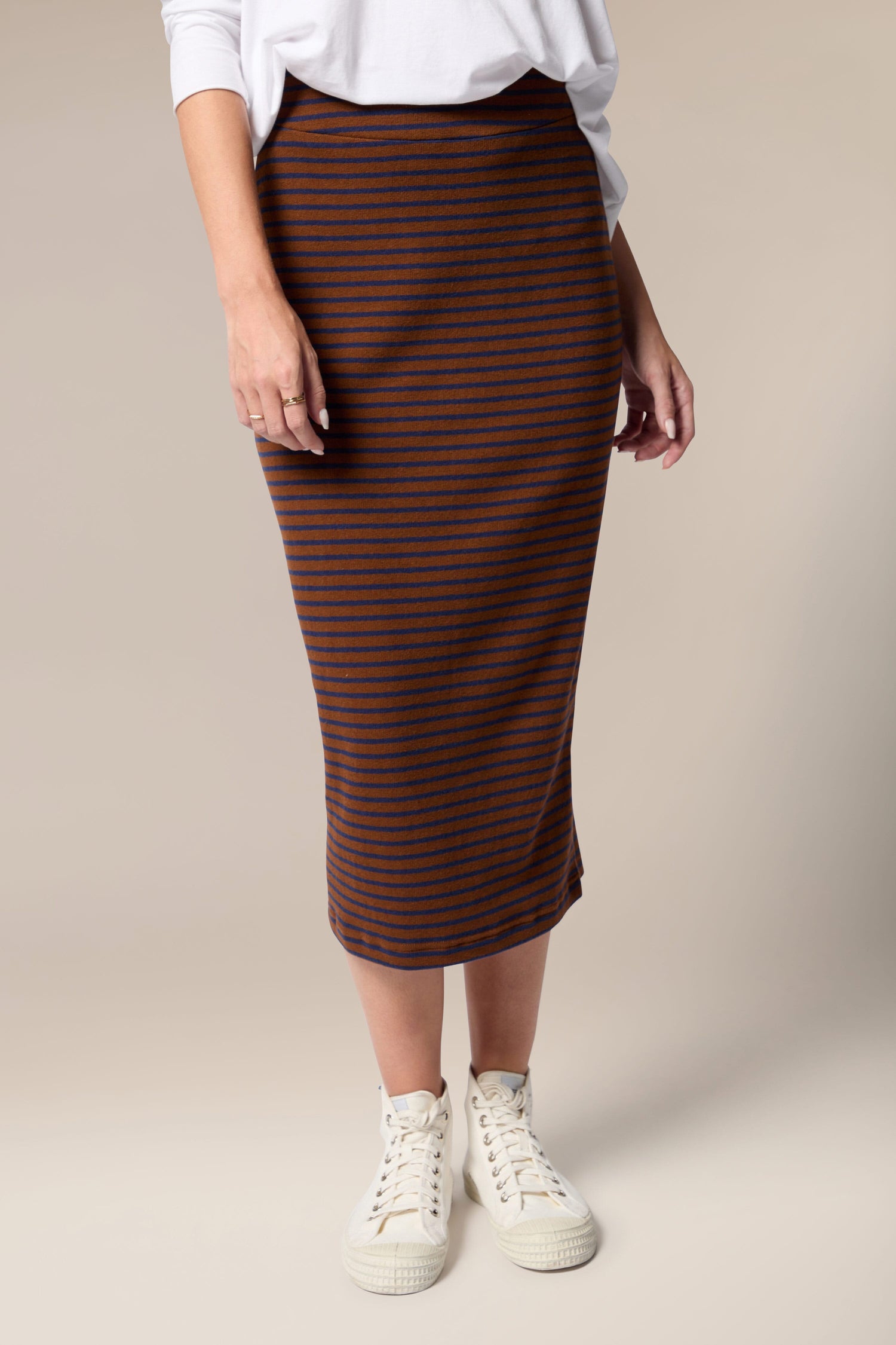 A woman wearing a Lilla Skirt made of soft touch woven fabric.
