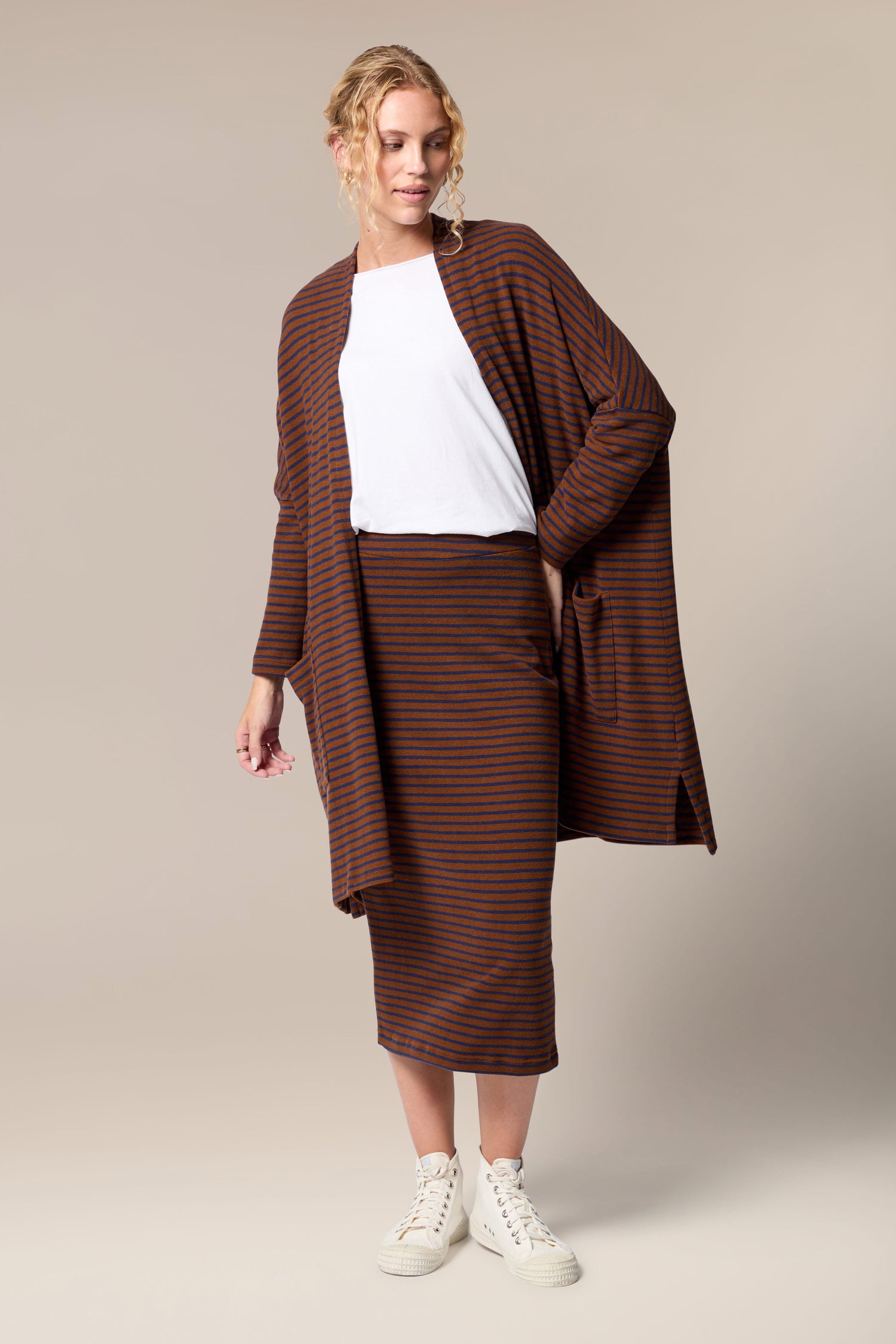 The model is wearing a soft touch woven fabric brown striped cardigan and Lilla Skirt.