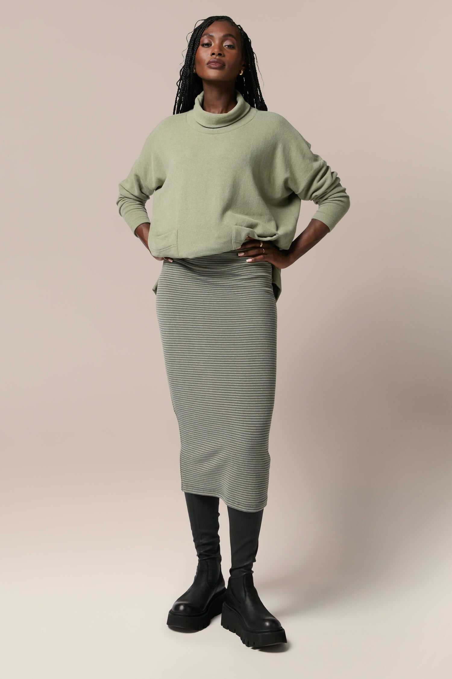 The model is wearing a Lilla skirt in sage green.