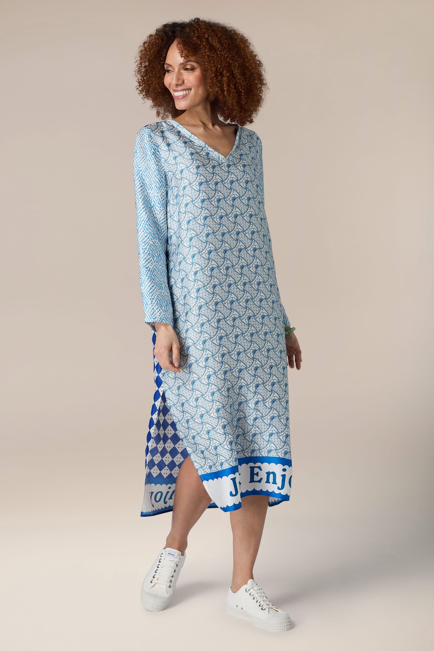 A woman in a Violet V-Neck T-Dress with a geometric print.