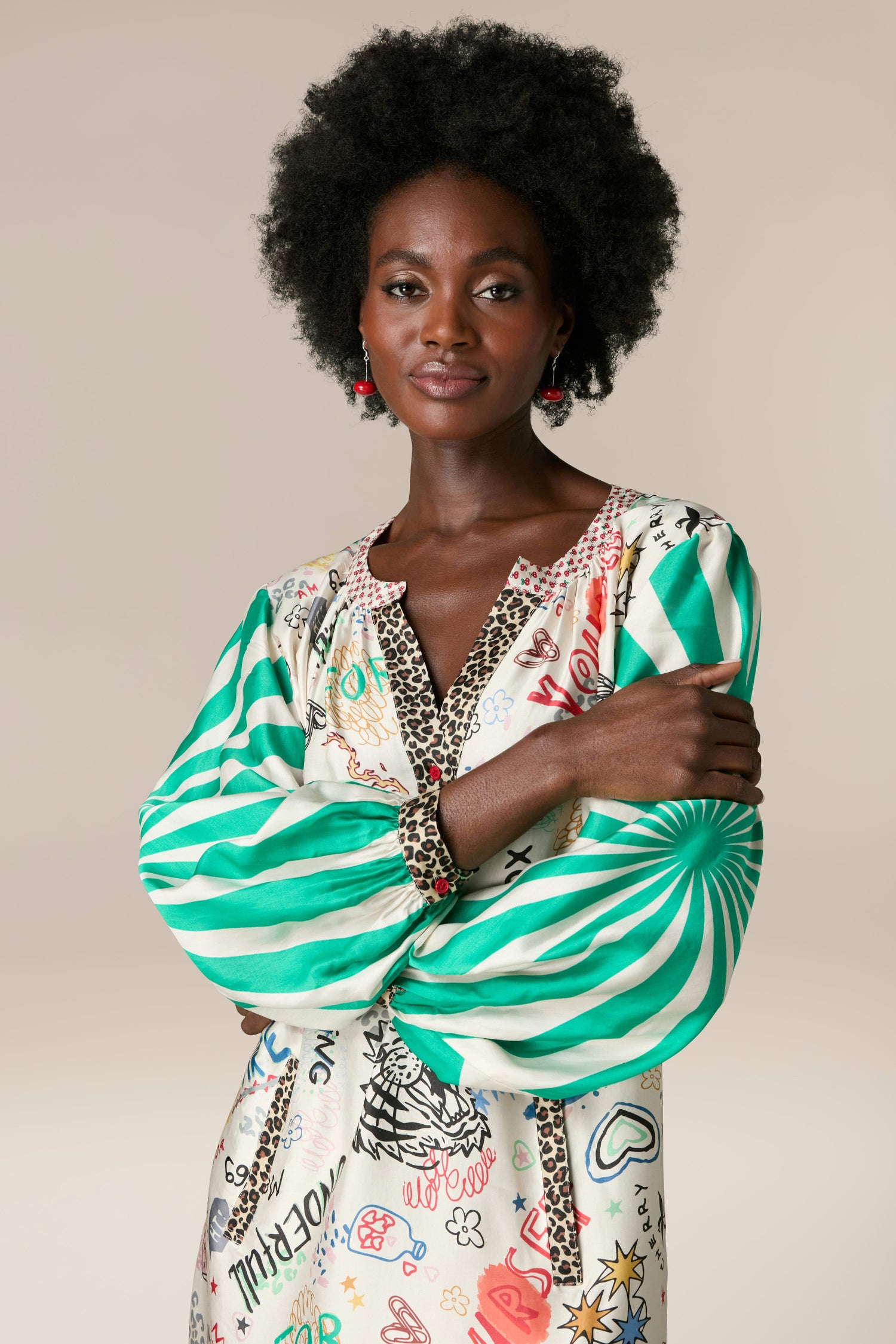 A black woman wearing a Hannah Deep V Neck Graffiti Dress made from silky flowing fabric.