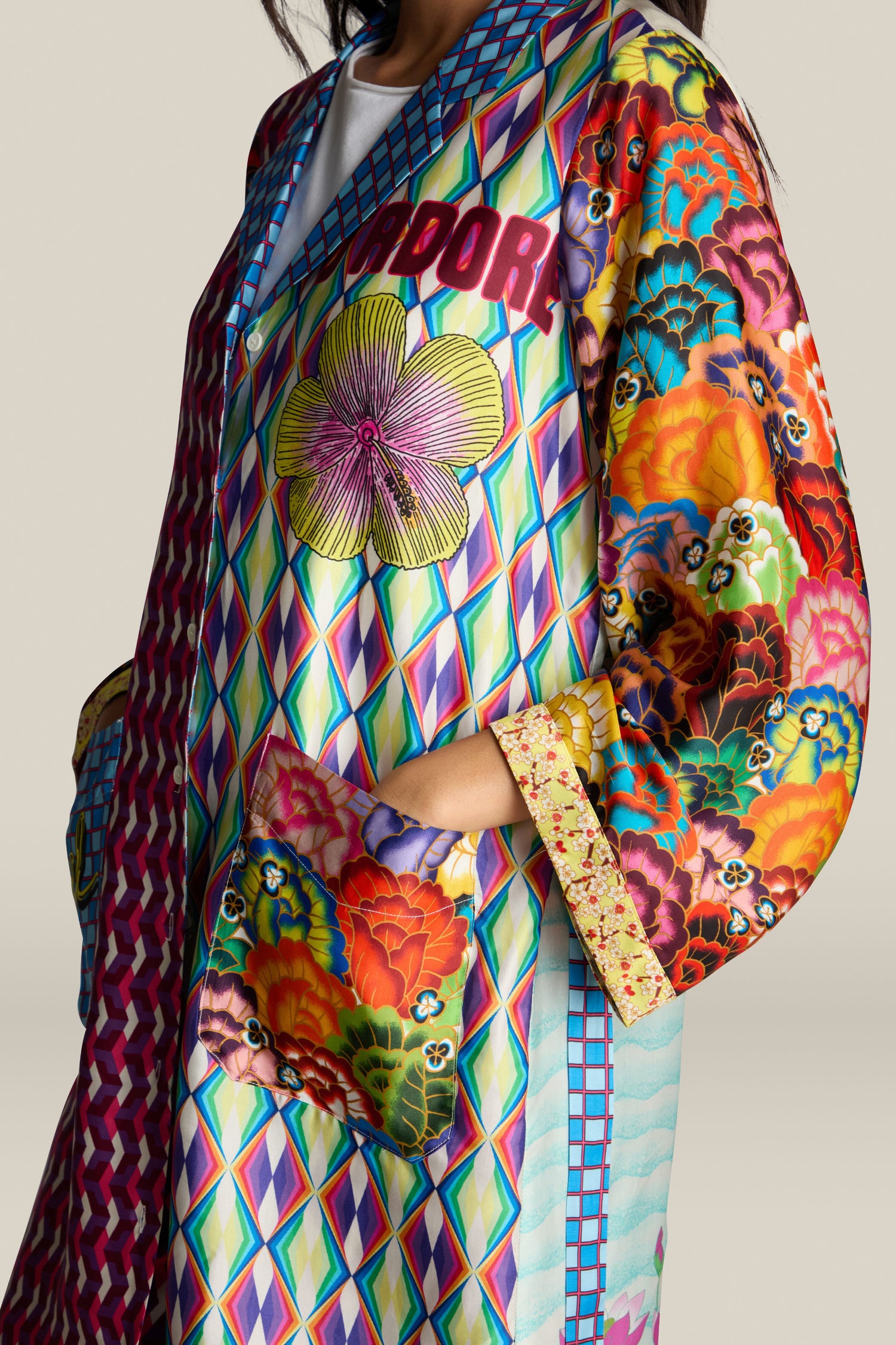 A person wearing the Nova Kimono, which features vibrant floral designs and geometric patterns on a plain background.