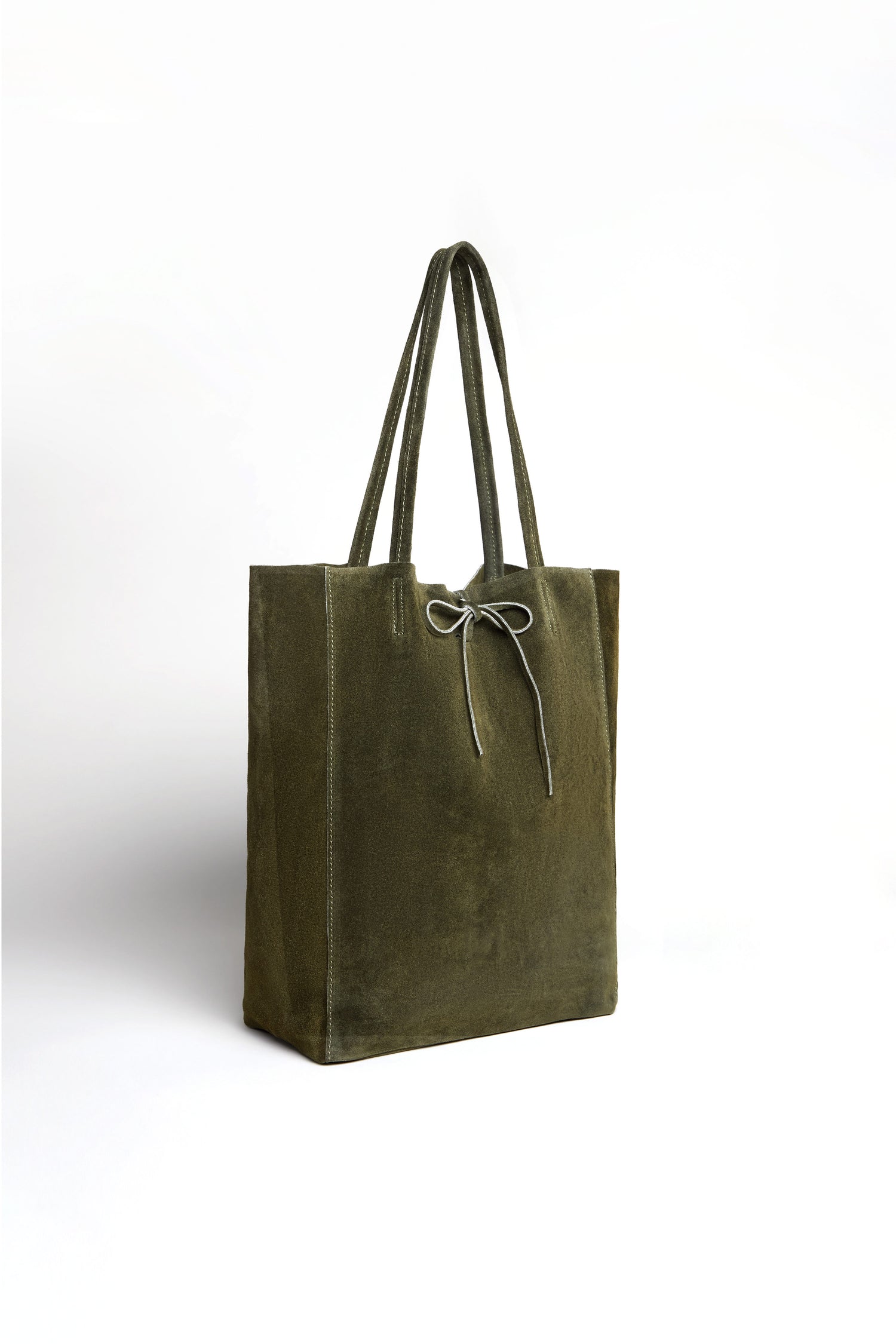 The Soft Suede Khaki Tote Bag features double handles and a tie closure, displayed standing upright against a plain white background. This spacious handbag combines everyday functionality with minimalist tote bag design.