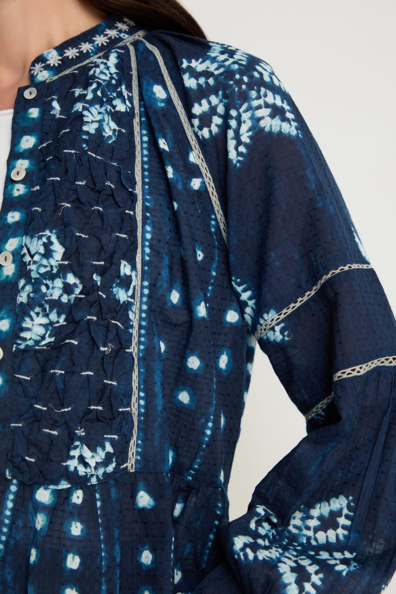 Close-up of a person wearing the Mixed Shibori Shirt in navy blue and white, featuring decorative stitching, embroidered trim, and button detailing on the front.