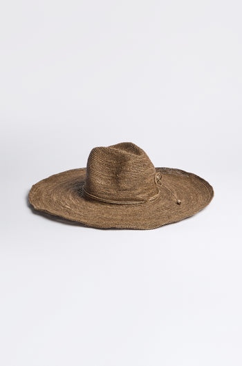A Hand Woven Double Crochet Raffia Hat, featuring a wide brim and elegant adjustable fit, is crafted from Madagascan raffia and displayed on a plain white surface.